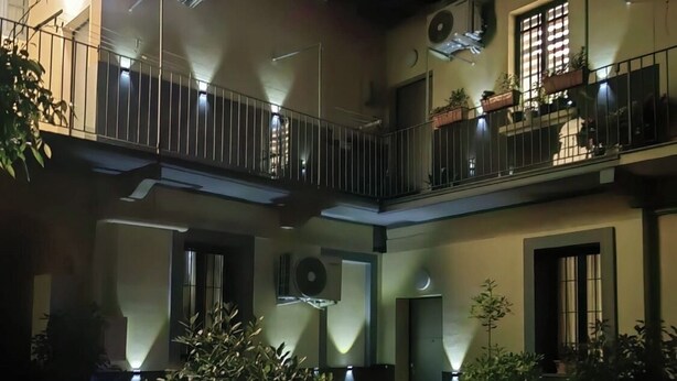 A multi-story building with balconies, outdoor lighting, and potted plants. - Promotion - Fully Equipped Studio for Short and Long Stays in Legnano (Legnano)