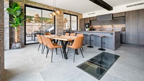 Enjoy meals in the spacious kitchen with a large island and dining area, offering a view of the surrounding landscape.