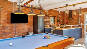 Een pooltafel met een blauwe viltkleed, een biljartkeu en één witte poolbal.