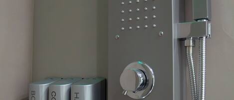 A modern shower control panel with multiple spray heads and a handheld showerhead.