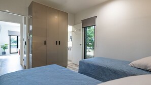 Una camera da letto con due letti, un armadio e una porta che dà su un bagno.