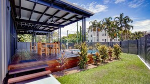A covered outdoor area with a pool, wooden deck, and seating. - Harper - the perfect holiday home (3 Bedroom) (Mission Beach)