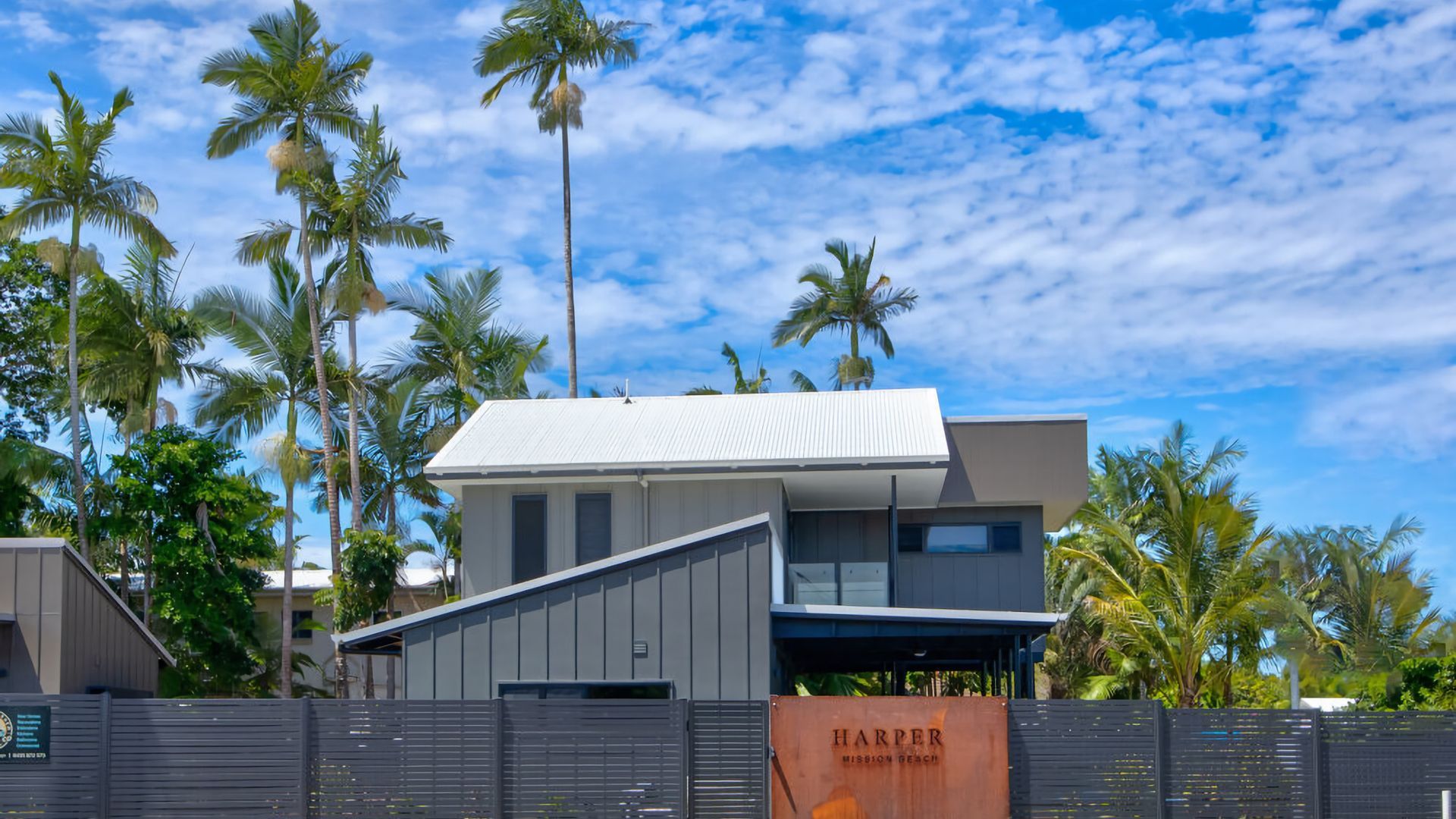 A modern two-story building with a flat roof and a large garage entrance.
