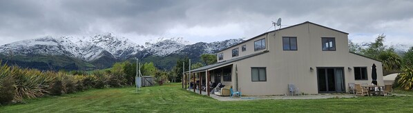 A two-story building with a flat roof, large windows, and a satellite dish. - Rural, idyllic, and 360 degree views! Spacious and only 15 minutes from Wanaka. (Hāwea Flat)