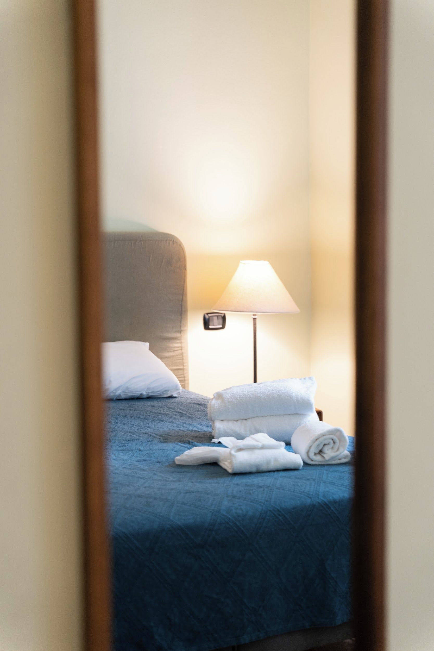 Une chambre d’hôtel avec un lit, une lampe et des serviettes.