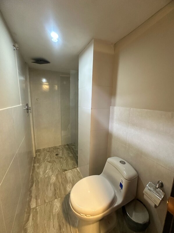 A bathroom with a toilet, a bidet, and a shower stall. - Coral Boutique Hotel (Medellín)