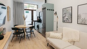 A compact living space with a kitchenette, a dining area, and a sofa.