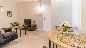 Uma sala de estar moderna com sofá, televisão e mesa de jantar com jogos americanos de fibra.