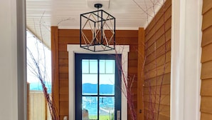 A wooden exterior with a blue door, large vases, and a geometric ceiling light. - THE FOX HOUSE on Flathead Lake: Lakefront Luxury Living (Bigfork)