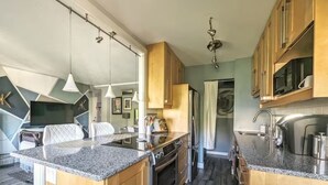 A modern kitchen with granite countertops, wooden cabinets, a built-in oven, and a stainless steel sink.