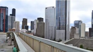 A rooftop terrace with a view of modern high-rise buildings.