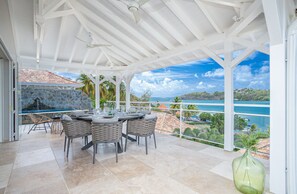 Enjoy a meal with a view of the ocean and surrounding landscape from this outdoor dining area.