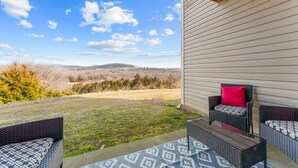 A patio with wicker furniture and a view of a hilly landscape. - Casa Bonita Azul | 3 bedroom | 2 bath | Sleeps 8 (Branson)