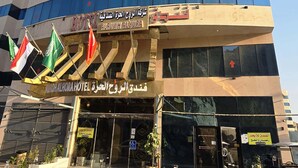 A hotel with multiple floors, large windows, and flags. - alroh alhora hotel (Makkah)