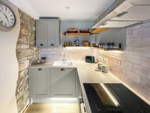A modern kitchen with grey cabinets, a white sink, and a black stove. - 2 bedroom accommodation in Kielder (Kielder)