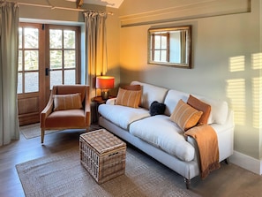 A living room with a sofa, armchair, and a small table with a lamp. - 2 bedroom accommodation in Kielder (Kielder)