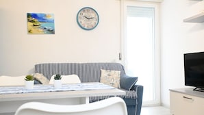 Un salon moderne avec un canapé, une table à manger et un téléviseur.