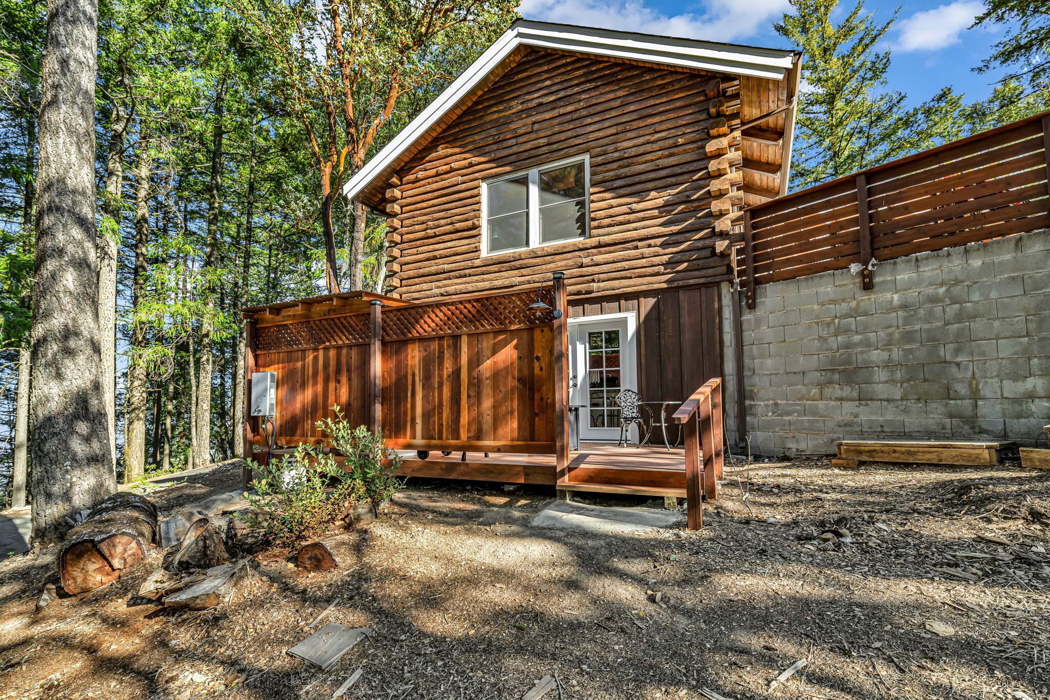 Une cabane en rondins avec un porche, une porte et une fenêtre.