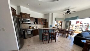 Una cocina amplia con una isla central, sillas de madera y un comedor.