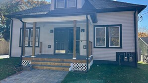 A two-story house with a front porch, a covered entryway, and a small front yard. - Feels Like Home - BBQ, Yard, Fire Pit (Fitchburg)