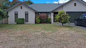 A modern two-story house with a garage, numbered 26, and a well-maintained lawn.
