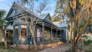 A two-story house with a porch, brick foundation, and a brick pathway leading to the entrance. - Midnight Moon Retreat (Beaufort)