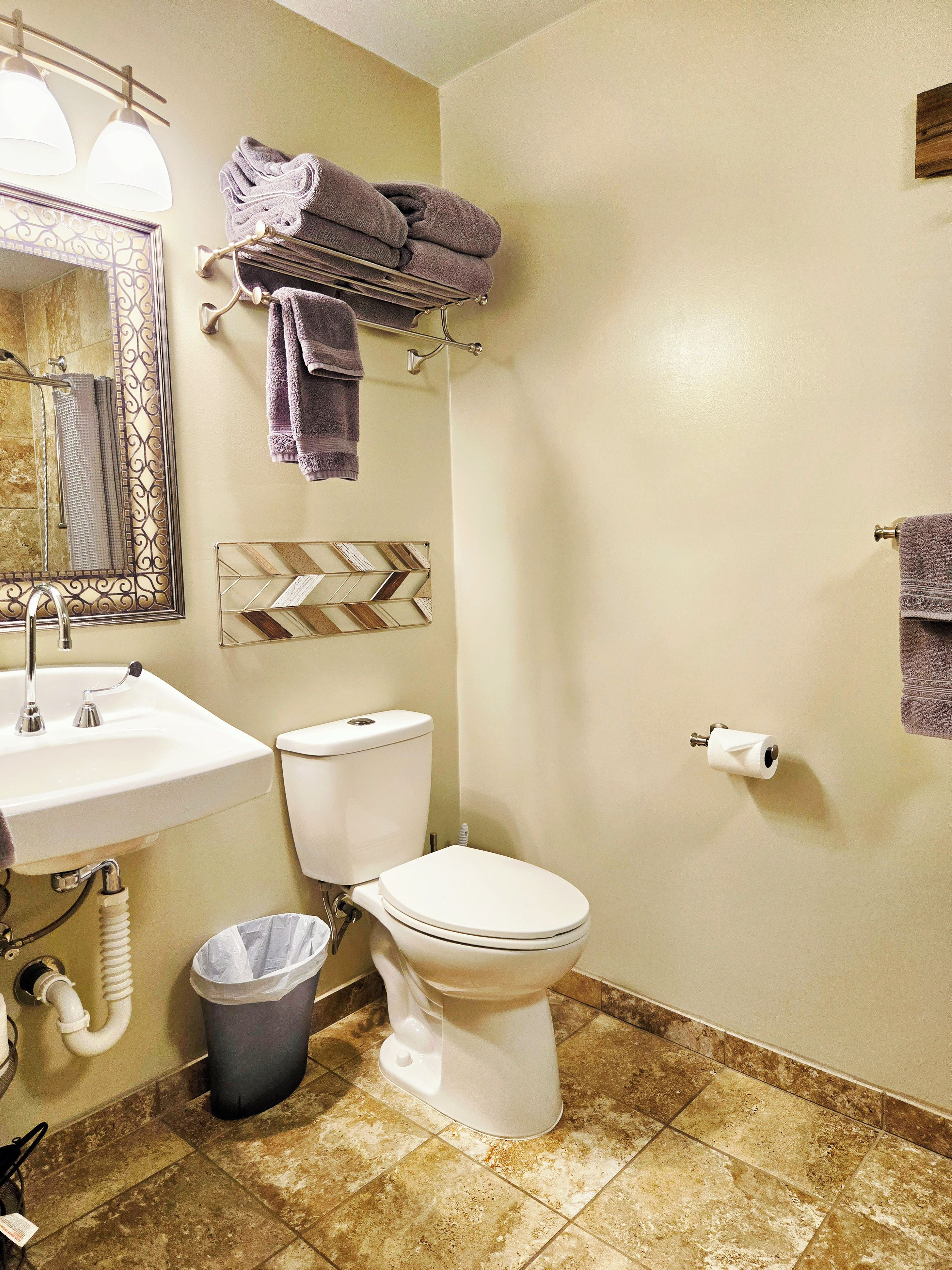 Une salle de bain équipée d’un lavabo, de toilettes et d’un porte-serviettes.