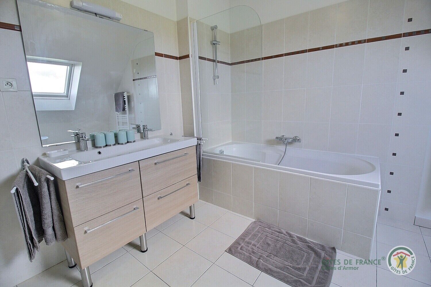 A modern bathroom with a sink, mirror, and shower.