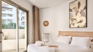 A hotel room with a large bed, a view through a sliding glass door, a radiator, and a framed artwork on the wall. - Jardines - Adama 1.3 POOL VIEW (Arona)