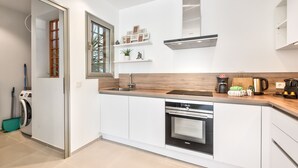 A modern kitchen with white cabinets, a built-in oven, and a coffee maker. - Jardines - Adama 1.3 POOL VIEW (Arona)