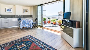 Ein modernes Apartment mit Küche, Essbereich und einem Balkon mit Blumentöpfen.