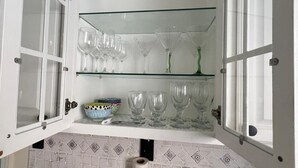 A kitchen with open cabinets displaying glassware and a decorative bowl. - Chic & Comfortable 1 bed apt with Parking. Walking distance JSQ path. Sleeps 4.  (Jersey City)