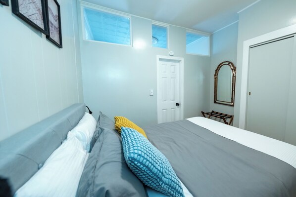 Une chambre à coucher avec un lit, un miroir et une porte.
