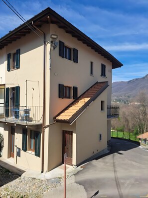 Un bâtiment à deux étages doté d’un balcon, d’une porte et offrant une vue sur le paysage environnant.