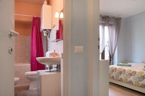 Une salle de bain avec des toilettes, un lavabo et une douche.