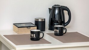 A kitchen counter with a coffee maker, two coffee mugs, a thermos, and a box. - Room 'Il Mappamondo -  Ensuite' with Wi-Fi and Air Conditioning (Catania)