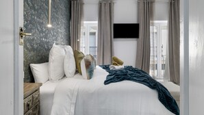 A bedroom with a bed, curtains, a television, and a ceiling fan. - Room 'Suite Diamante' with Mountain View, Shared Terrace and Wi-Fi (Alcalá del Valle)