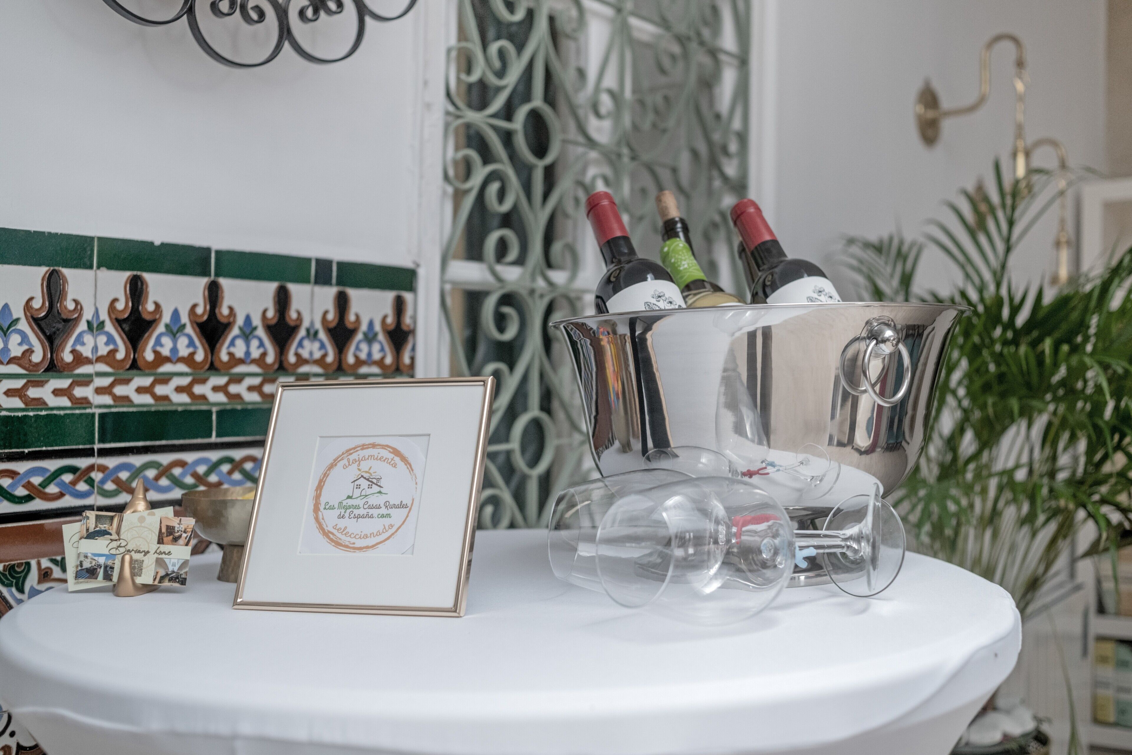 Une table avec un certificat encadré, un seau à champagne avec des verres et des bouteilles.