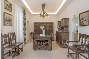 Une pièce avec une table en bois, des chaises, un lustre et des meubles en bois richement décorés.