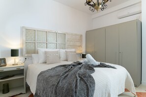A bedroom with a bed, bedside tables, a wardrobe, and a decorative wall panel. - Room 'Zirconio' with Mountain View, Shared Terrace and Wi-Fi (Alcalá del Valle)