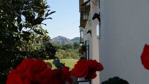 A building with a white exterior, a black horse head decoration, and a view of mountains in the background. - Villa 'La Priorita' with Mountain View, Wi-Fi and Air Conditioning (Córdoba)
