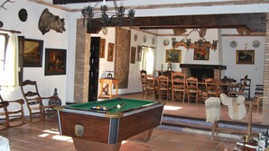 A room with a pool table, wooden chairs, a fireplace, and various wall decorations. - Villa 'La Priorita' with Mountain View, Wi-Fi and Air Conditioning (Córdoba)