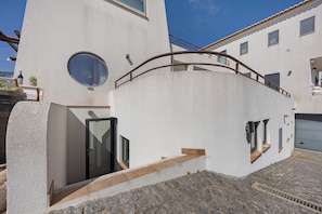 A modern building with a circular window, a staircase, and a garage.