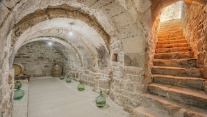 A stone-walled corridor with a staircase leading to an upper level.