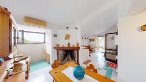 A room with a fireplace, wooden furniture, a tiled floor, and a window. - Villa 'Ersilia' with Sea View, Wi-Fi and Air Conditioning (Campulongu)