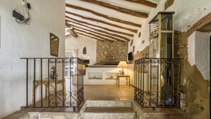 A stone staircase leading to a room with a stone wall, a wooden ceiling, and a metal railing. - Country House 'Casa Rural La Pallissa Con Piscina' with Mountain View, Shared Pool and Wi-Fi (Llampaies)