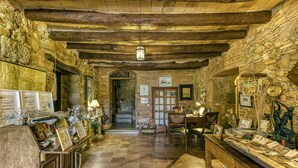 A rustic interior with stone walls, wooden beams, a reception desk, and a tiled floor. - Country House 'Casa Rural La Pallissa Con Piscina' with Mountain View, Shared Pool and Wi-Fi (Llampaies)