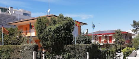 A residential area with houses, satellite dishes, and flags.