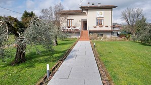 Un bâtiment à deux étages, avec un chemin pavé menant à l’entrée.