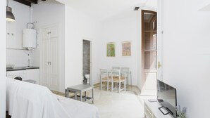 A small, clean room with a bed, a desk, a chair, a TV, and a window. - Apartment 'Sevilla Centro Con Piscina' with Shared Pool, Wi-Fi and Air Conditioning (Sevilla)